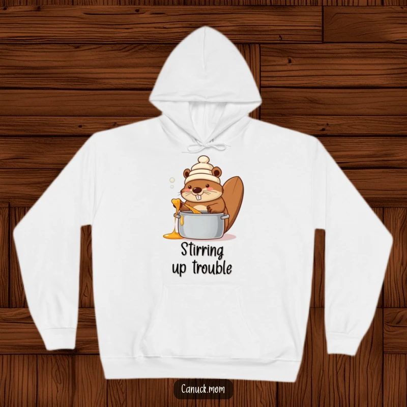 Funny beaver wearing a toque, stirring a pot of maple syrup, printed on a warm, comfortable hoodie, radiating cozy Canadian charm.
