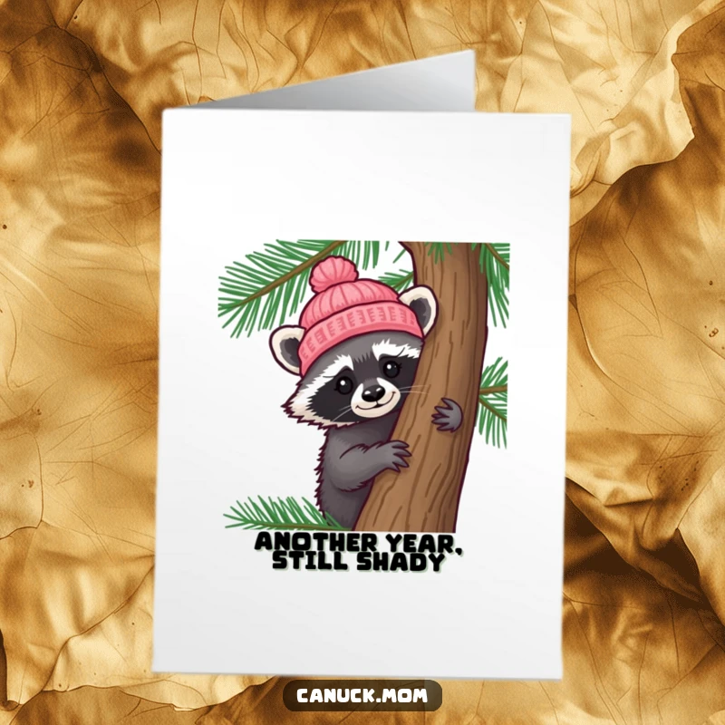 Funny Free Printable Birthday Card: A curious racoon in a knitted hat peeks playfully from behind a pine tree.